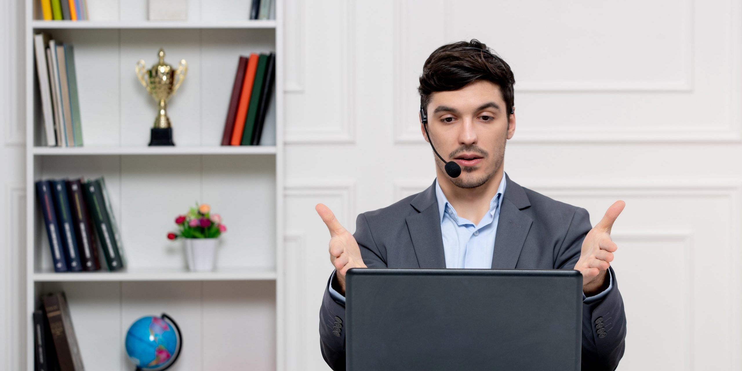 customer-service-cute-guy-in-grey-suit-with-computer-and-headset-talking-with-the-client