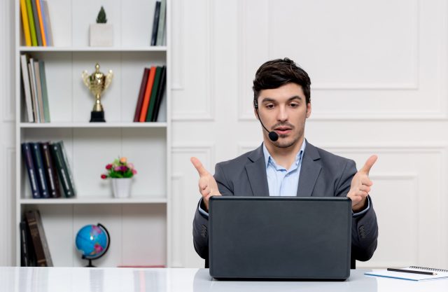 customer-service-cute-guy-in-grey-suit-with-computer-and-headset-talking-with-the-client